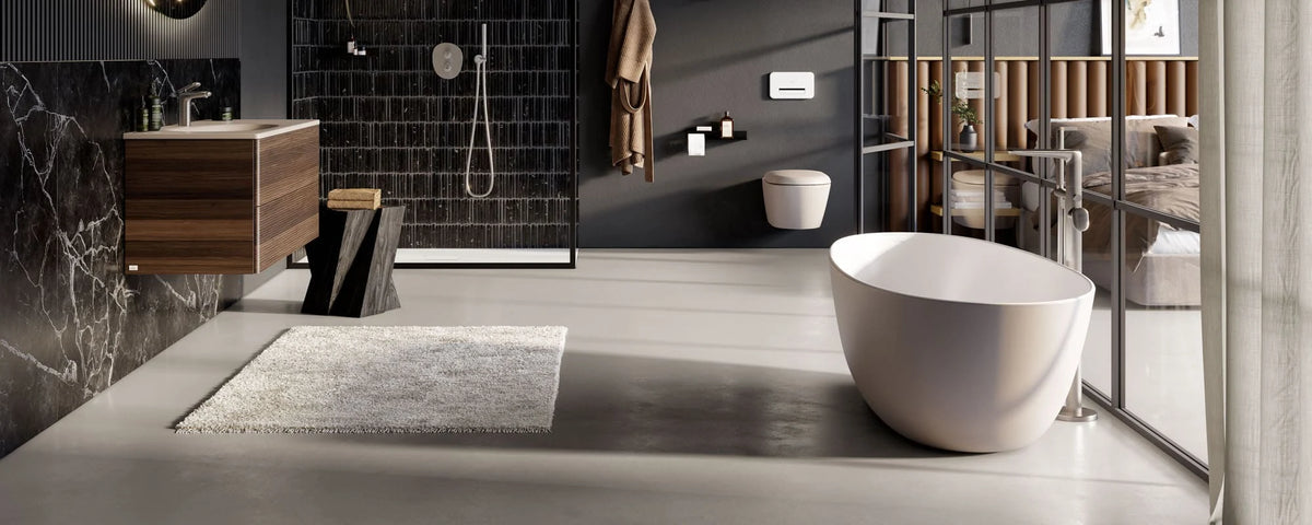 Floorstanding bath mixer with handset beside a freestanding bath in a bathroom setting
