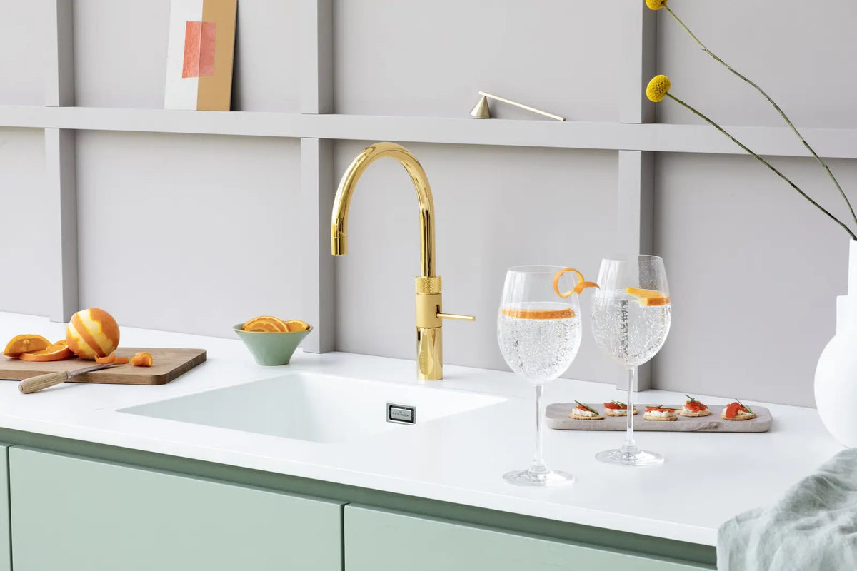 Quooker — A golden tap in a green kitchen